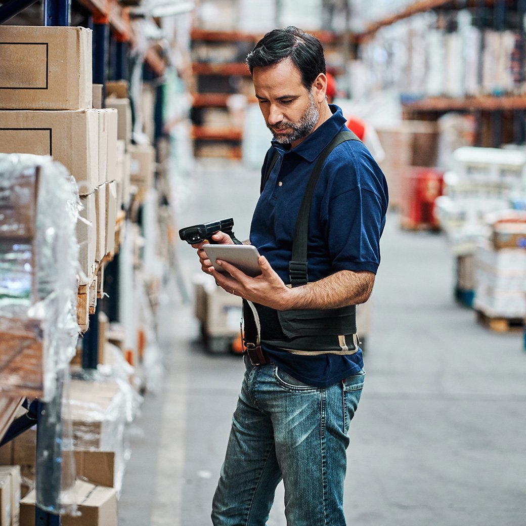 employee working on the manufacturing shop floor using a scanning device and docket software