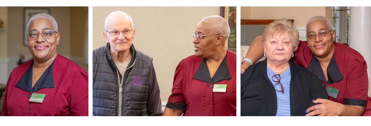 A caregiver in a red uniform smiles beside older residents in a senior living community, showing support and companionship.