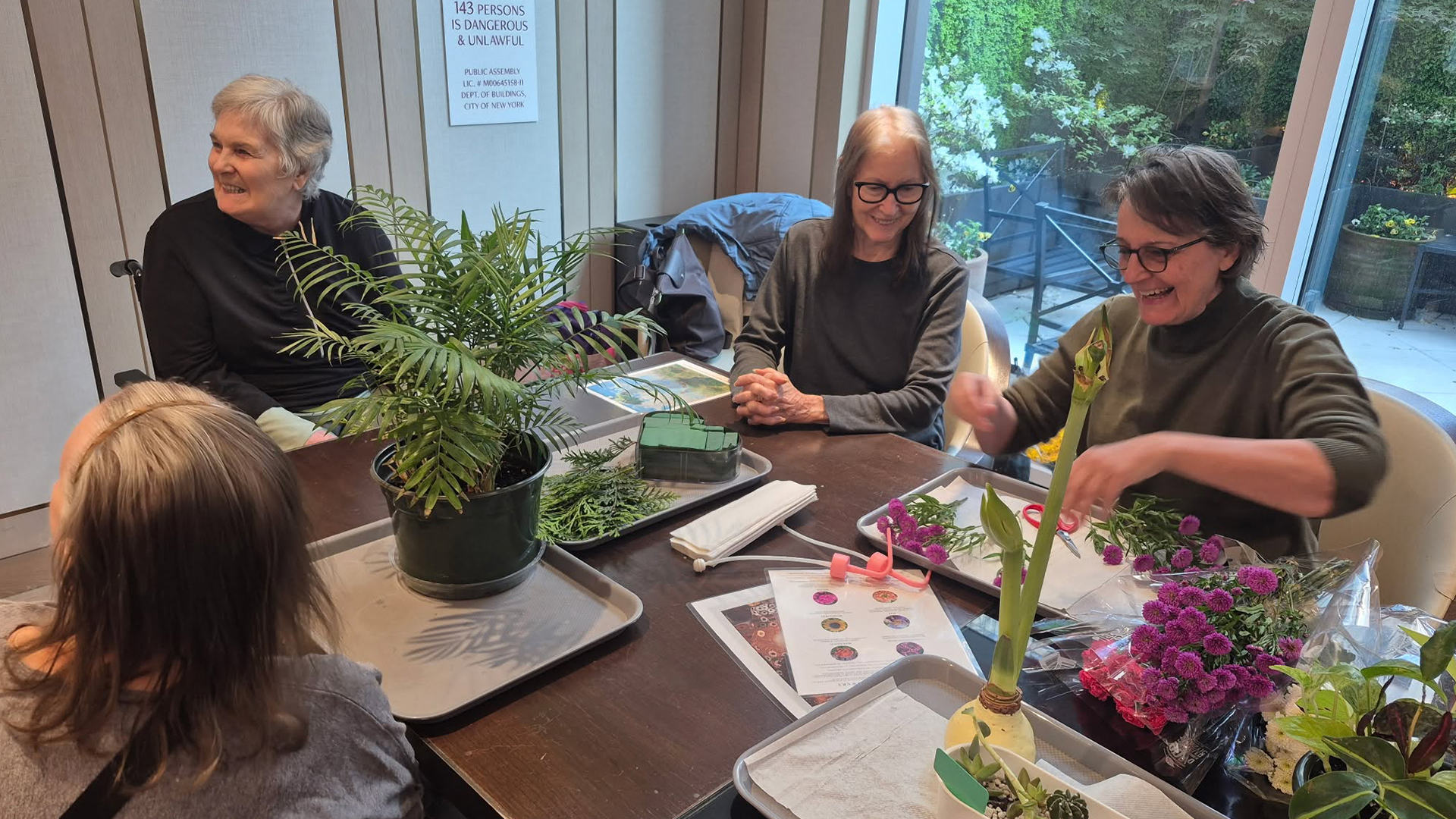 Memory care residents participate in a flower arranging workshop.