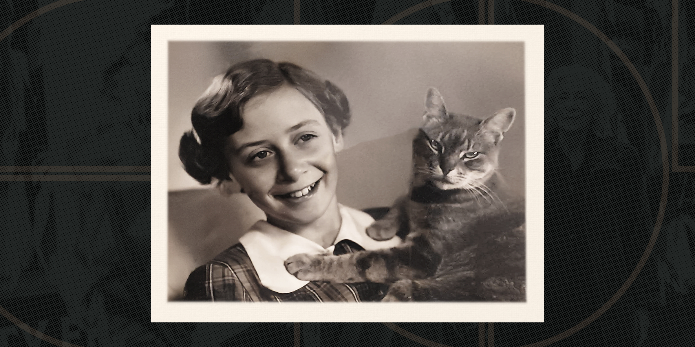Smiling girl with short hair holds a relaxed cat, both facing the camera. The image has a vintage sepia tone.