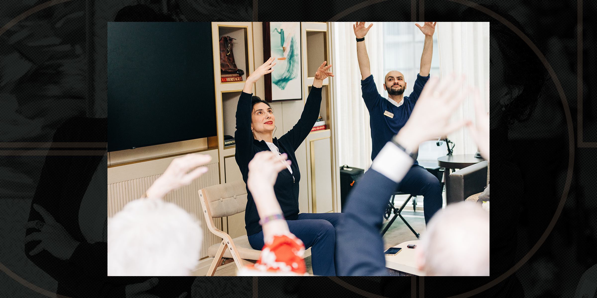 Memory Care Resident Engagement Specialist Sandra R leading a group session in an indoor setting with light streaming through a window.