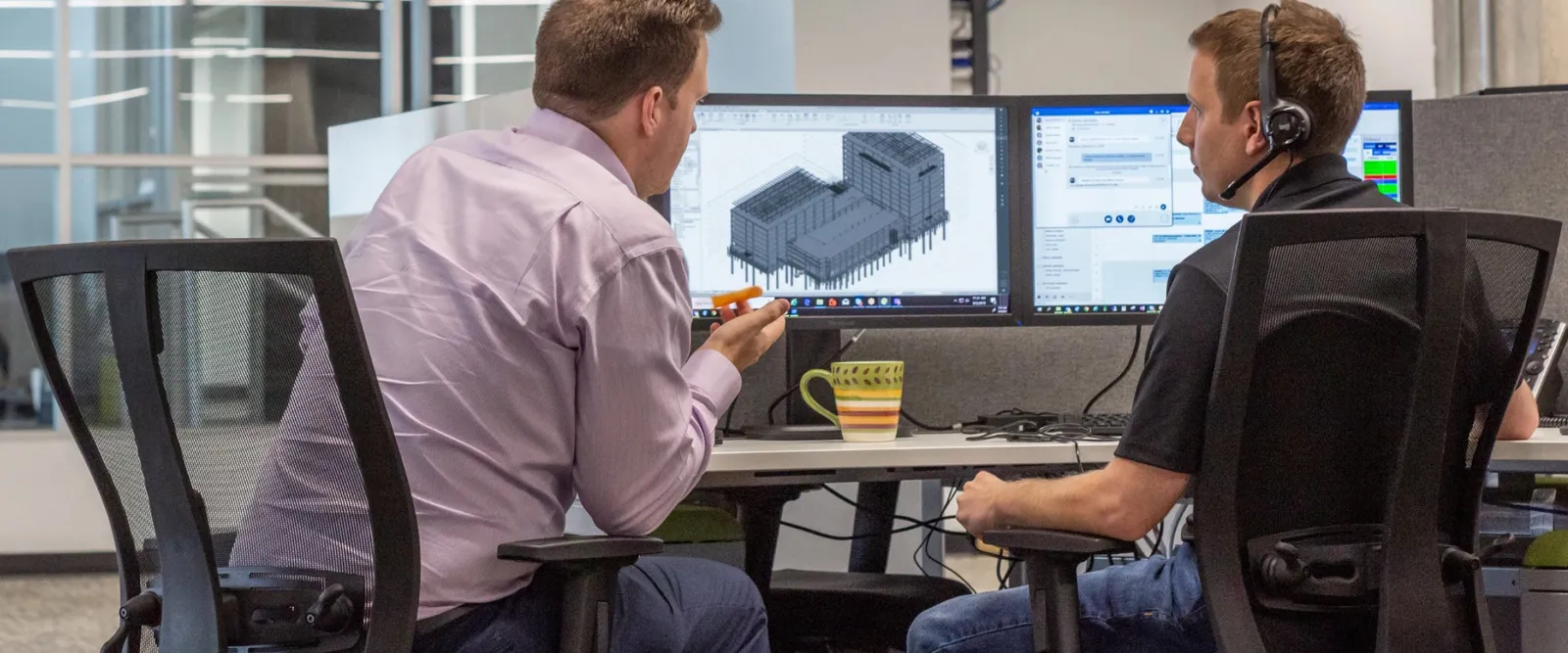 BIM Data Model Conditioning. BIM managers looking at data on a computer.