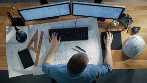 Birdseye view of subcontractor at computer working on construction prequalification.