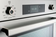 Stainless steel oven with digital clock displaying 10:39, control knobs, and a handle.