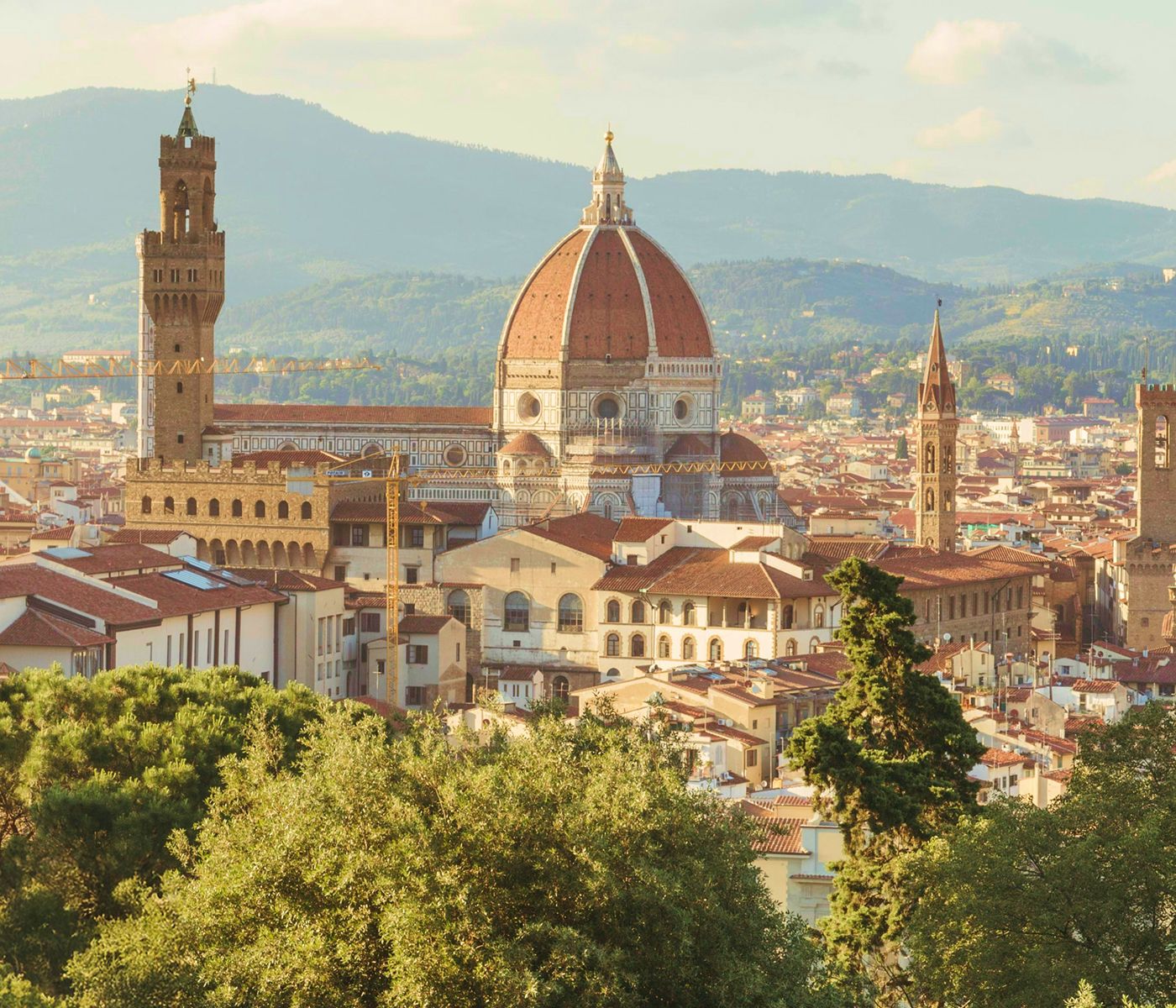 Scenic view of Florence, Italy, featuring the Florence Cathedral with its iconic dome, surrounded by historic buildings and hills in the background.