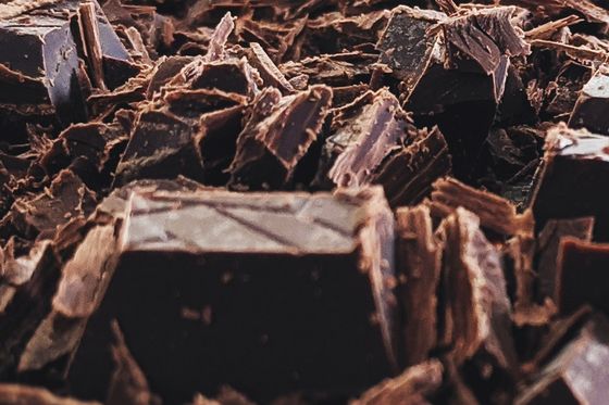 Close-up of dark chocolate pieces and shavings on a work surface during a chocolate-making workshop in Turin.