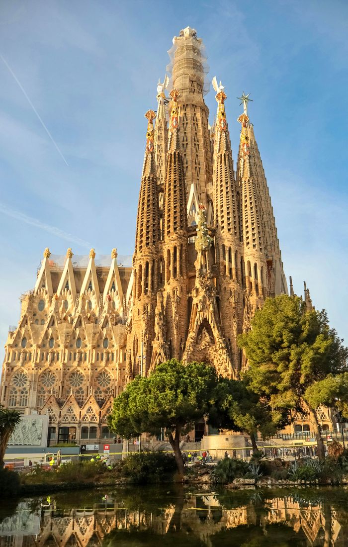 The Sagrada Família, an iconic basilica with towering spires and intricate Gothic architecture, under a clear blue sky in Barcelona.