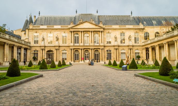 Front view of the elegant Hôtel de Soubise in Paris, featuring a cobblestone courtyard, manicured gardens, and classical architecture.