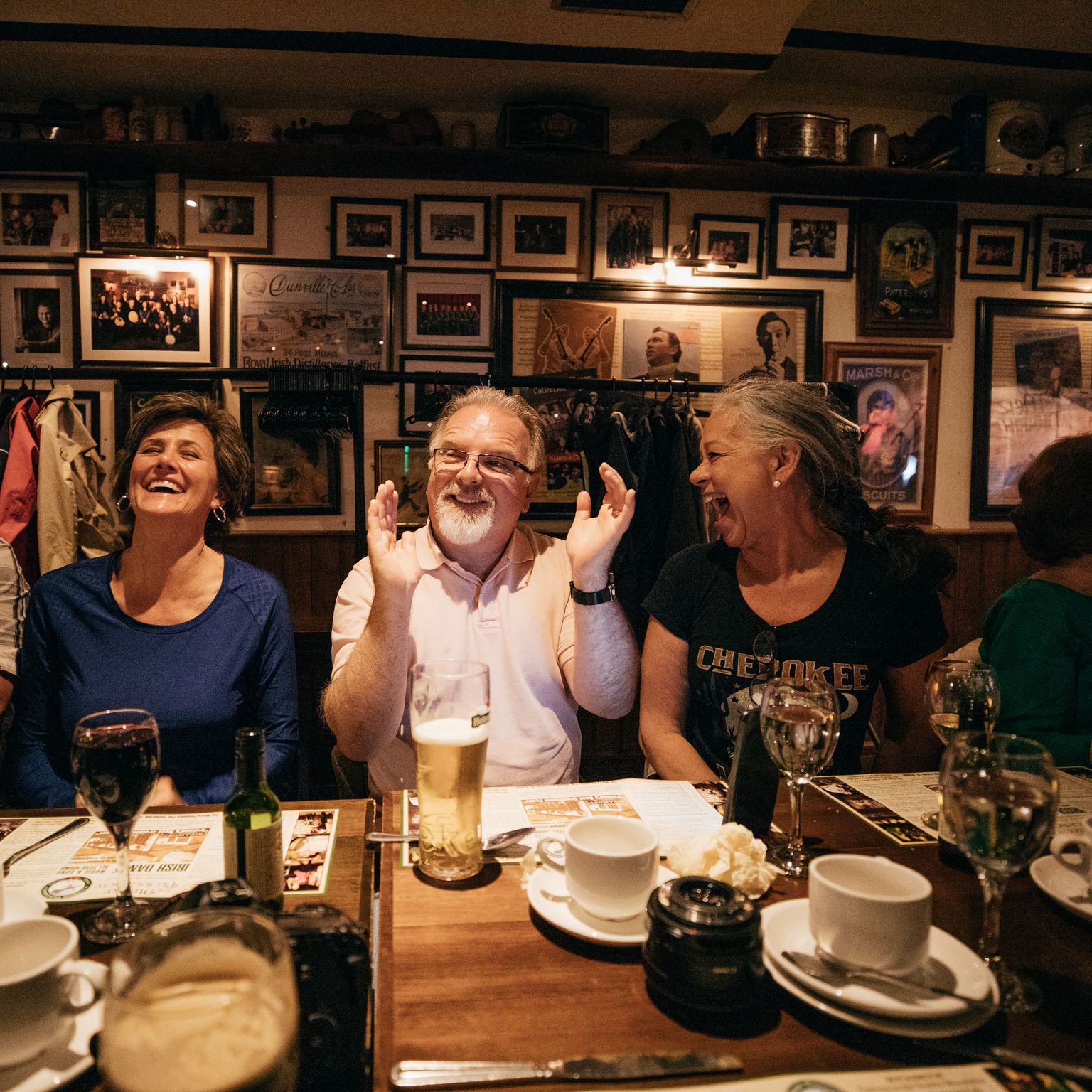 a group of travelers smiling and laughing at a dinner table