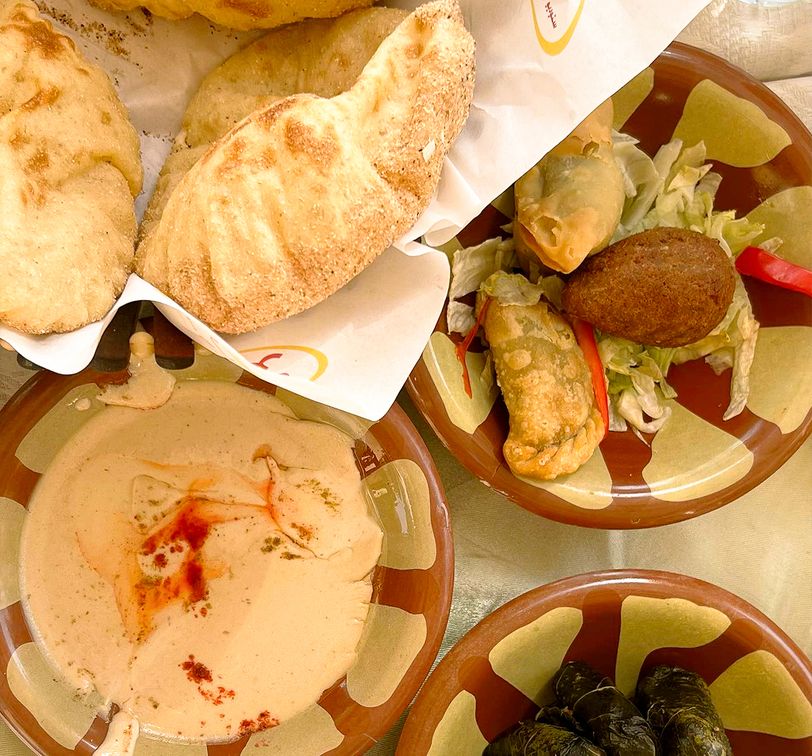 Bread and plates of Egyptian food on a table