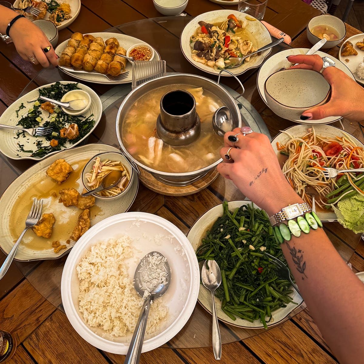 A table full of various traditional Thai foods.