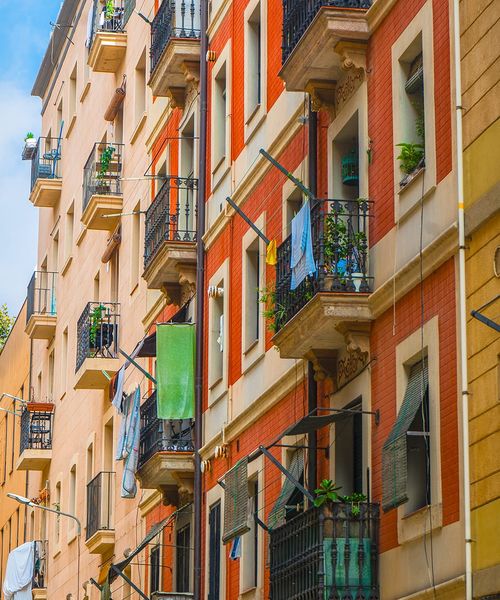 Red and yellow buildings with balconies and clothes hanging out to dry.