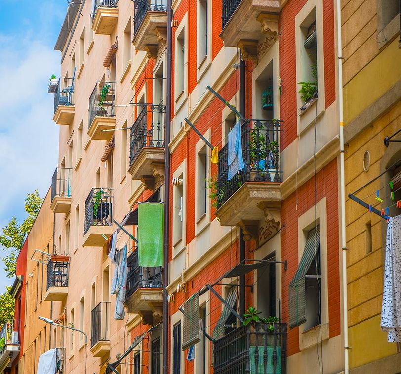 Red and yellow buildings with balconies and clothes hanging out to dry.
