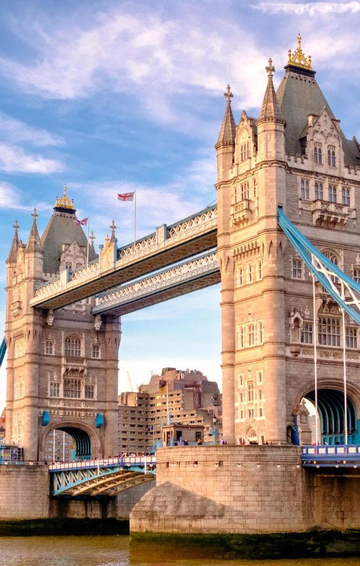 Tower Bridge in London with a clear blue sky, featuring its two distinct towers connected by a suspended walkway.