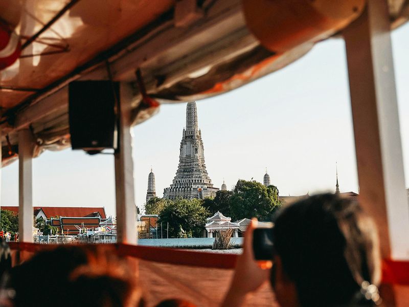 A view of a temple through the window of a boat in Bangkok.