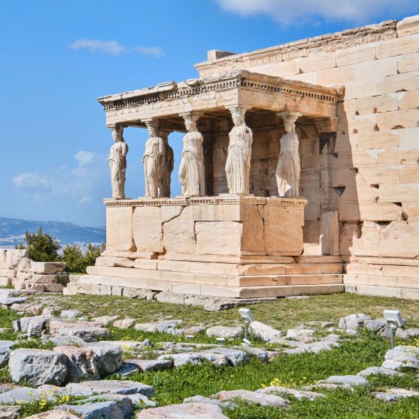 The Erechtheion with six Caryatid statues on the Acropolis in Athens, Greece, under a clear blue sky.