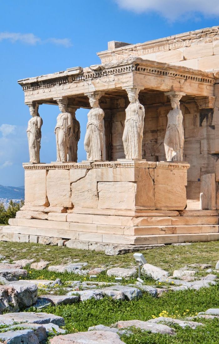 The Erechtheion with six Caryatid statues on the Acropolis in Athens, Greece, under a clear blue sky.
