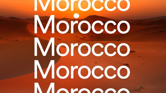 Text "Morocco" repeated over a sunset desert landscape with orange dunes and visible sun.