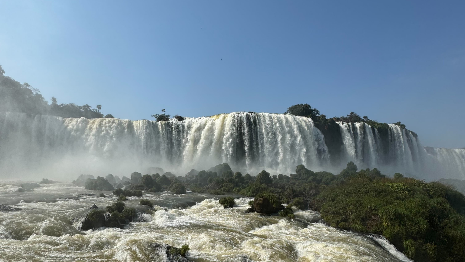 A huge waterfall, trees, and rushing river
