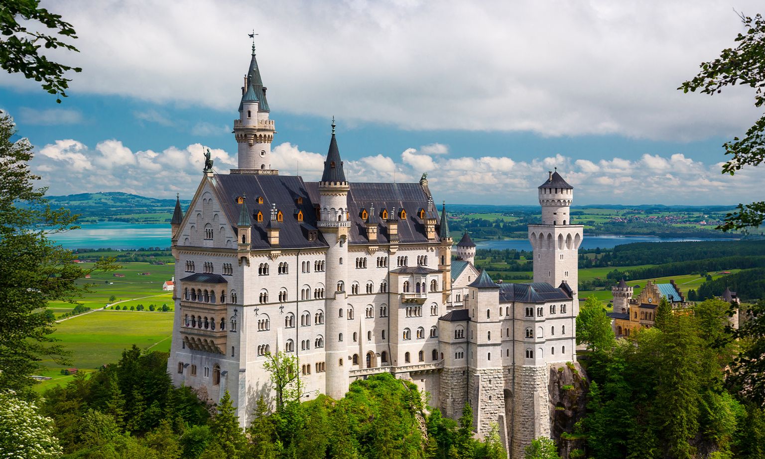 Panoramic view of Neuschwanstein Castle with the lake in the distance near Munich, Germany.