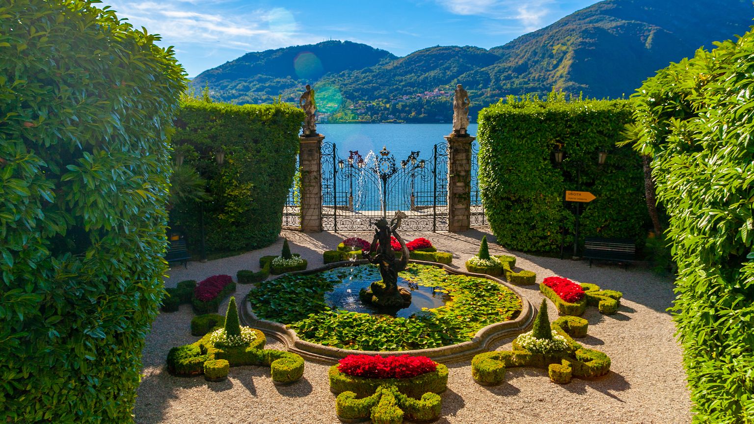 A fountain, gate, and manicured hedges of Villa Carlotta on Lake Como