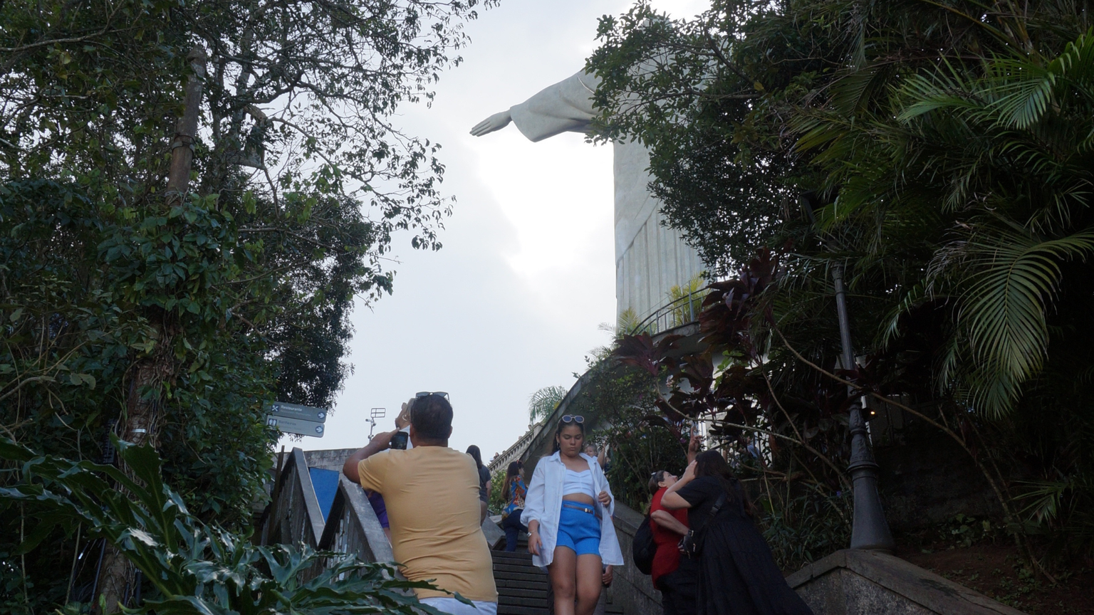 People walking up a staircase through a jungle to see Christ the Redeemer statue