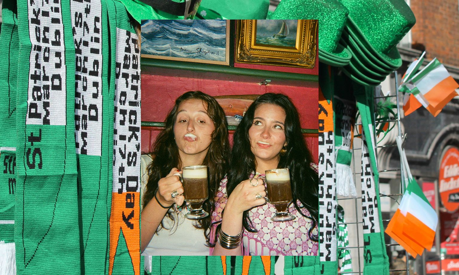 Two women with mustaches made of foam, holding mugs, overlay on a festive background with St. Patrick's Day scarves and Irish flags.