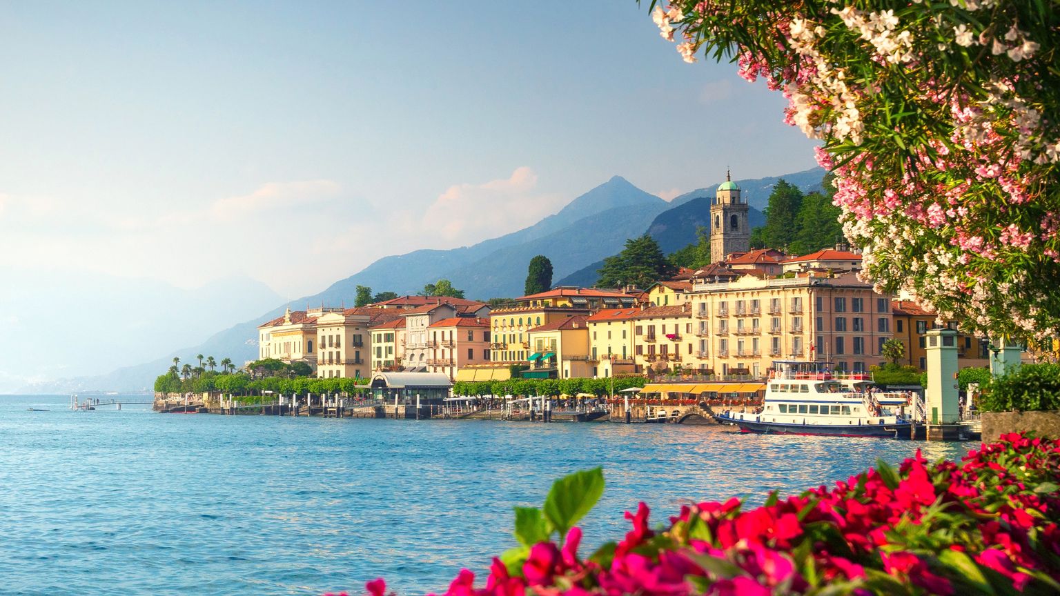 The town of Bellagio on the shore of Lake Como surrounded by mountains and blooming flowers