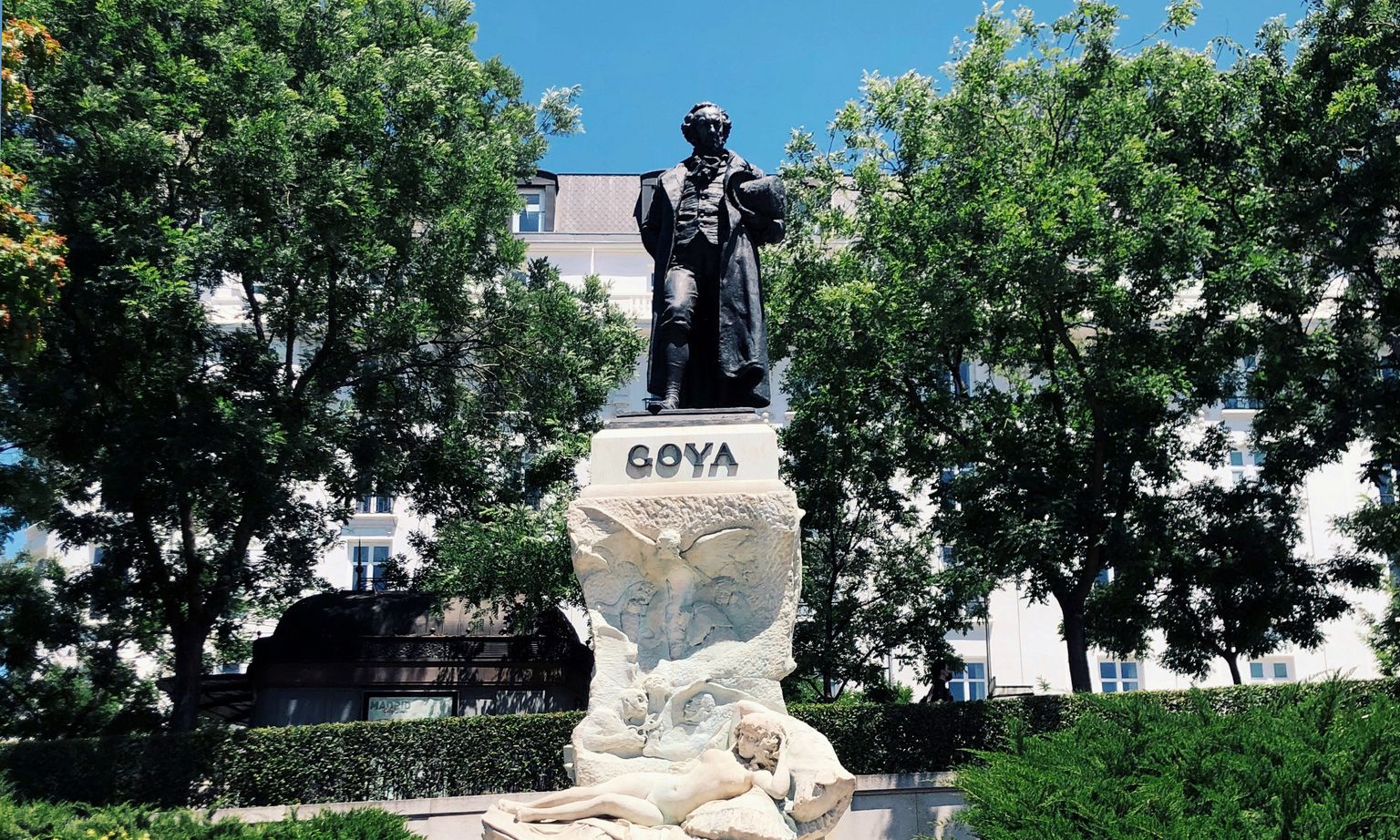 A statue of the artist Francisco Goya in a leafy green park in Madrid, Spain