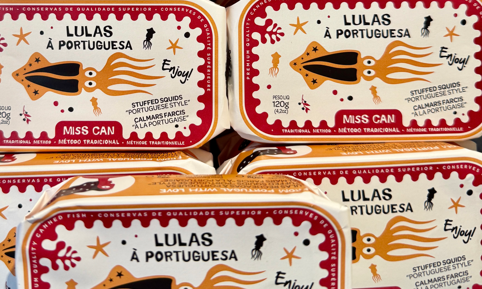 Tins of octopus wrapped in colorful paper featuring an octopus illustration and starfish from the Portuguese brand Miss Can