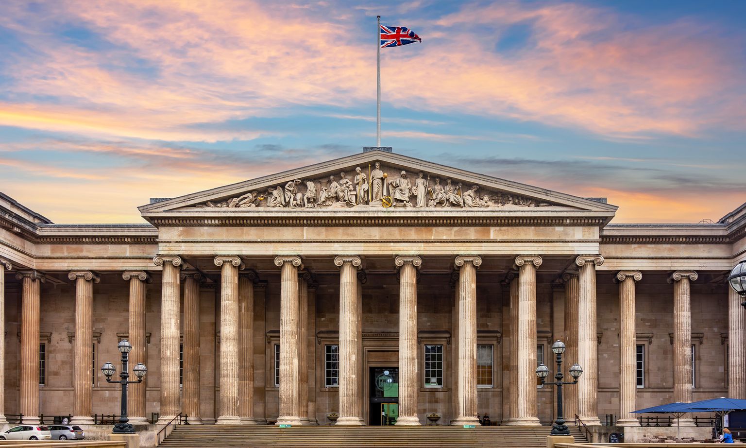 The British flag flying over the Greek-revival columns of the British Museum in London, England