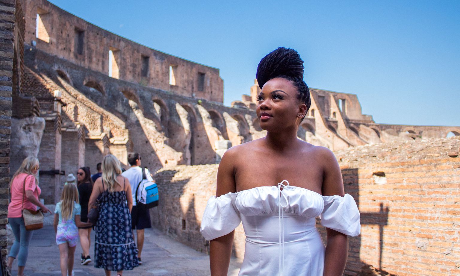 A woman posing within the ruins of the Colosseum's amphitheater in Rome, Italy