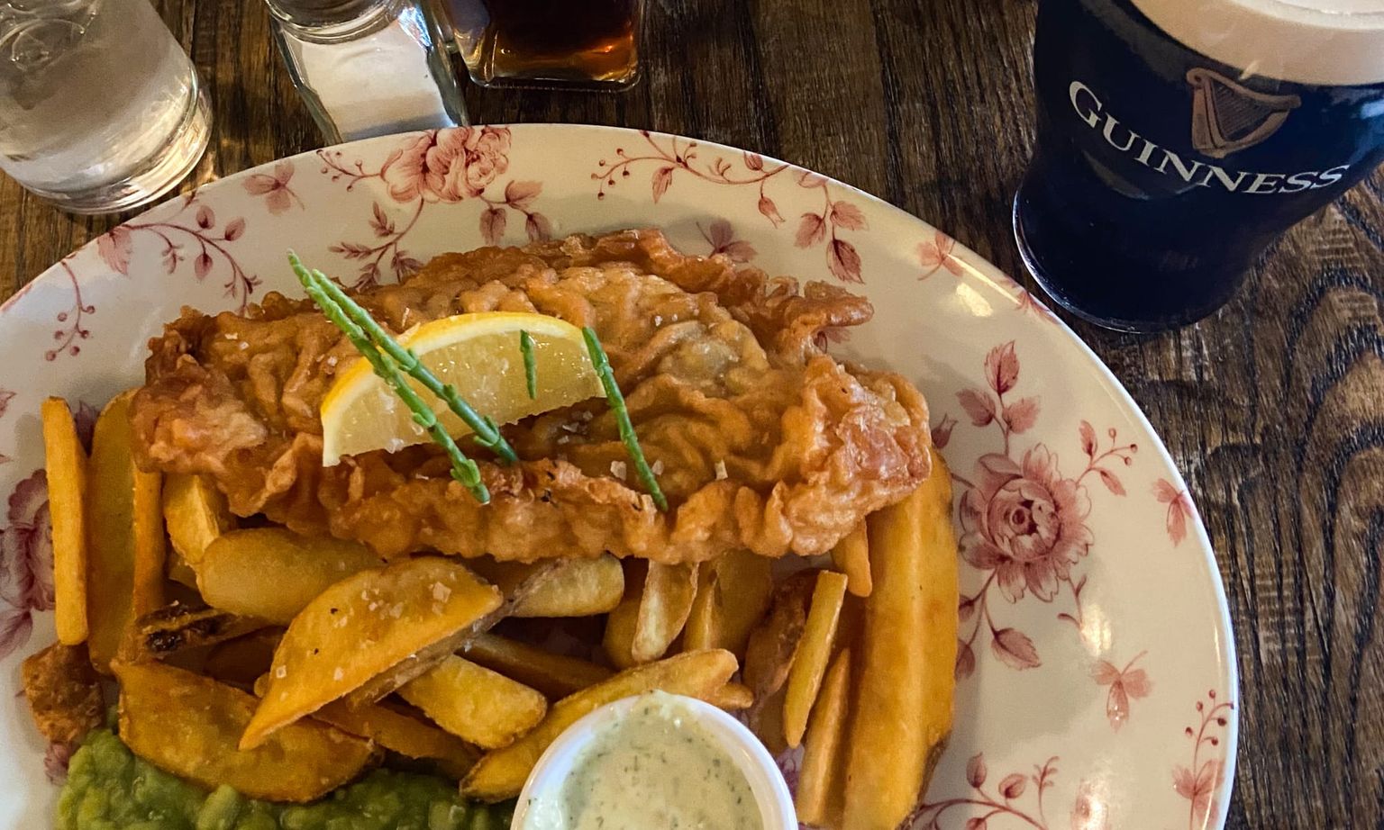 A plate of fish and chips and a pint of Guinness beer on a table in Dublin, Ireland