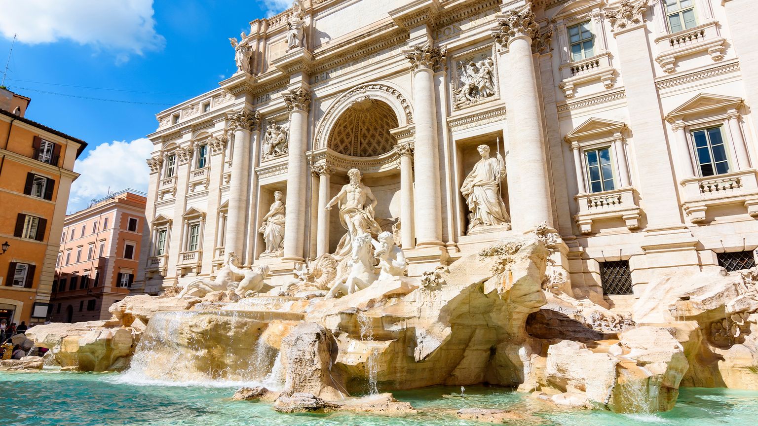 The Trevi Fountain, a large fountain with statues in front of a grand building in Rome, Italy