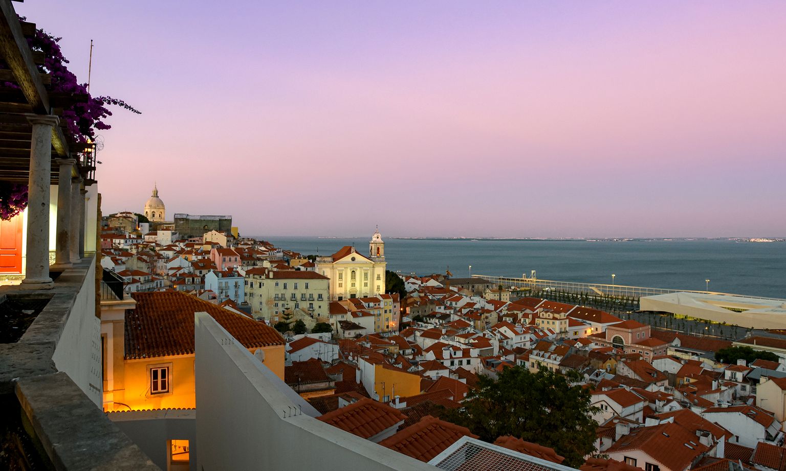 Sunset over the Tagus River and the red rooftops of Lisbon from a hilltop viewpoint