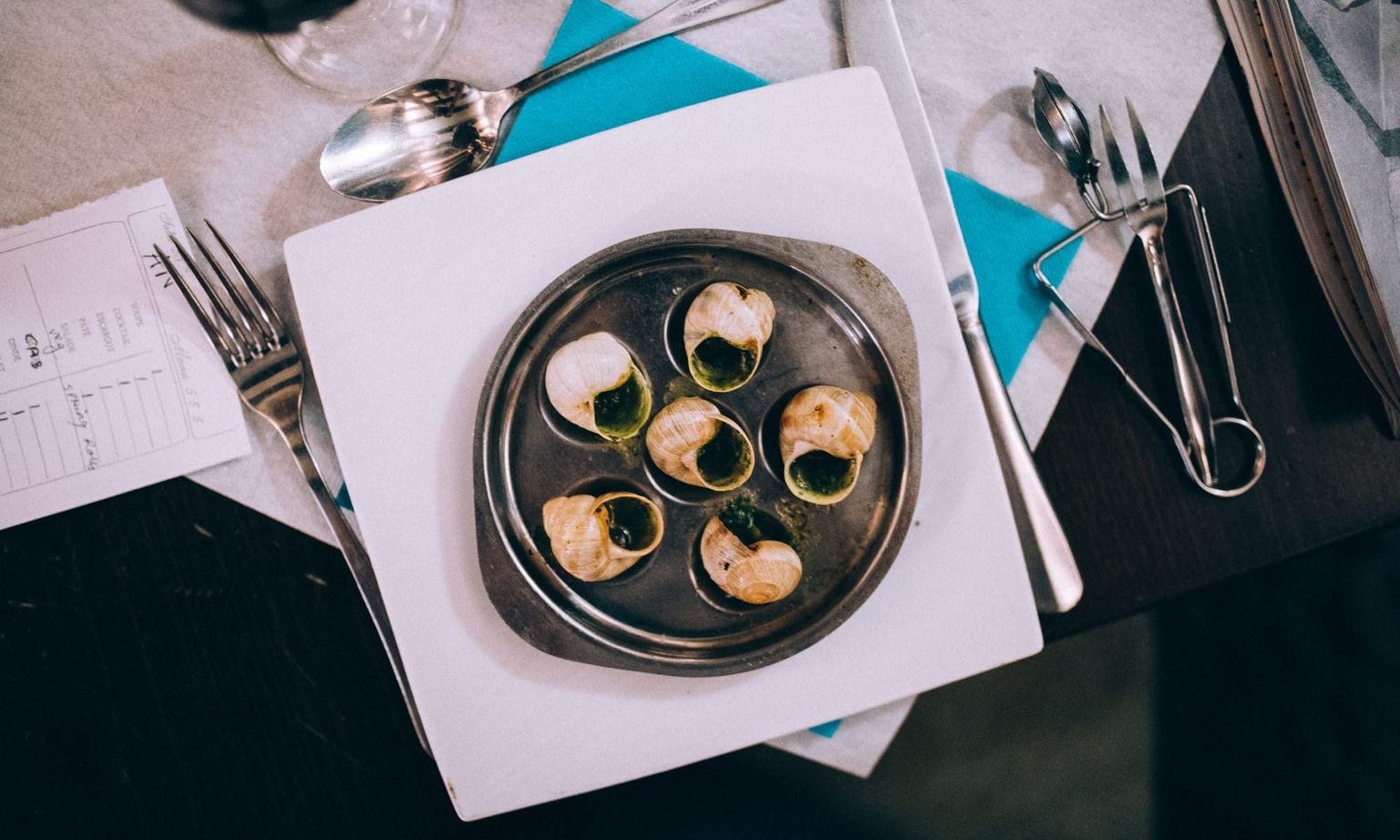 Escargot (snails) on a silver plate and silverware on a table in Paris, France