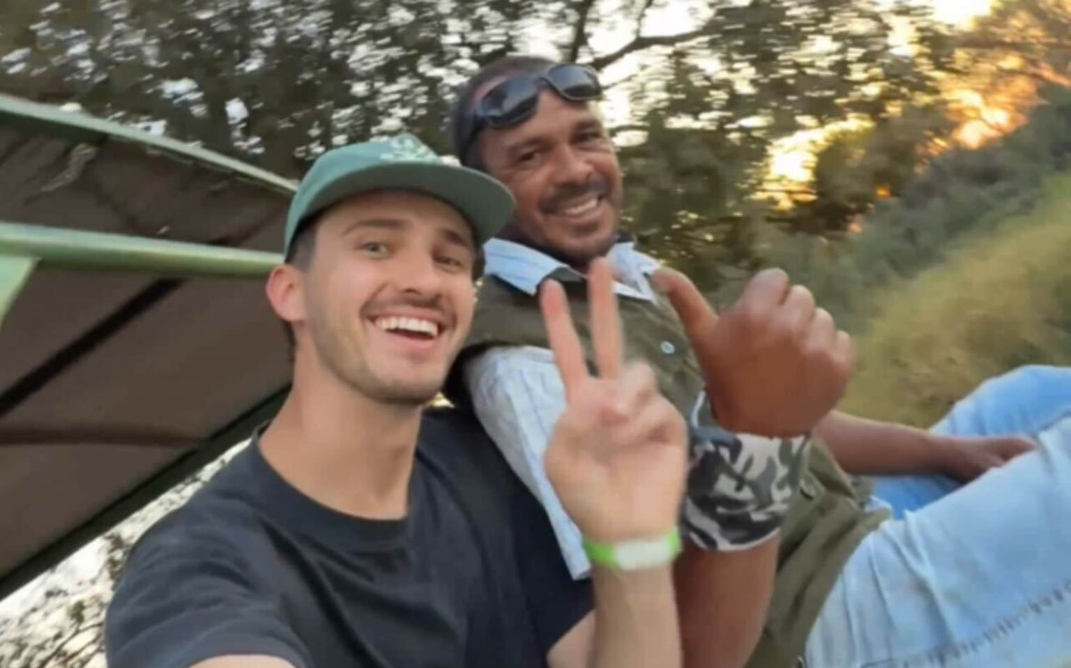 Two men on an off-road vehicle smiling for the camera