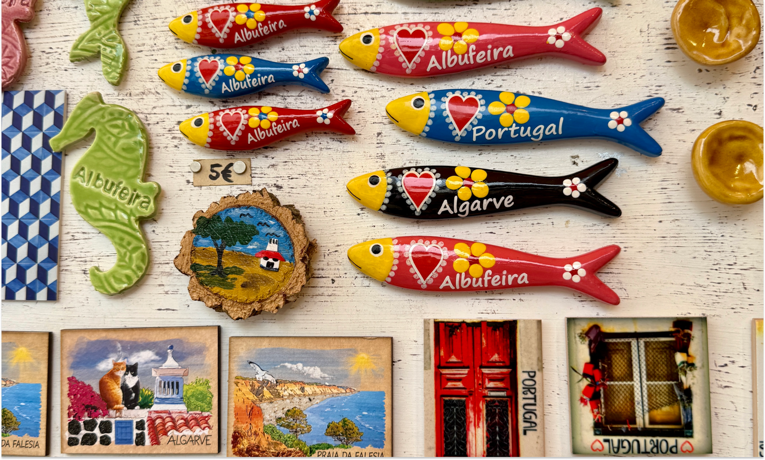 Colorful refrigerator magnets that say "Portugal" and "Albufeira"