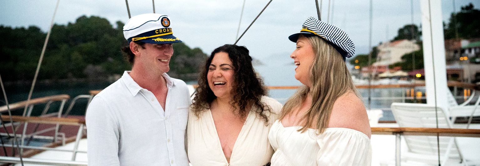 A group of friends in sailor hats on a boat in Croatia