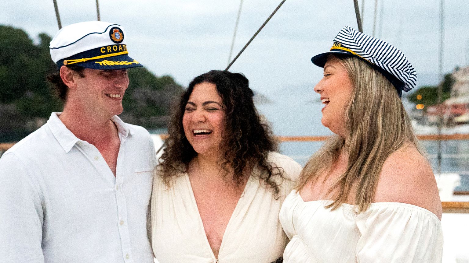 A group of friends in sailor hats on a boat in Croatia