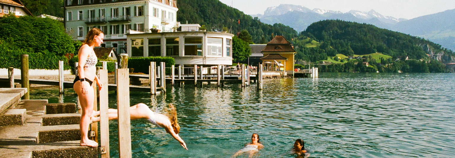 Two women jumping into a lake in Switzerland.