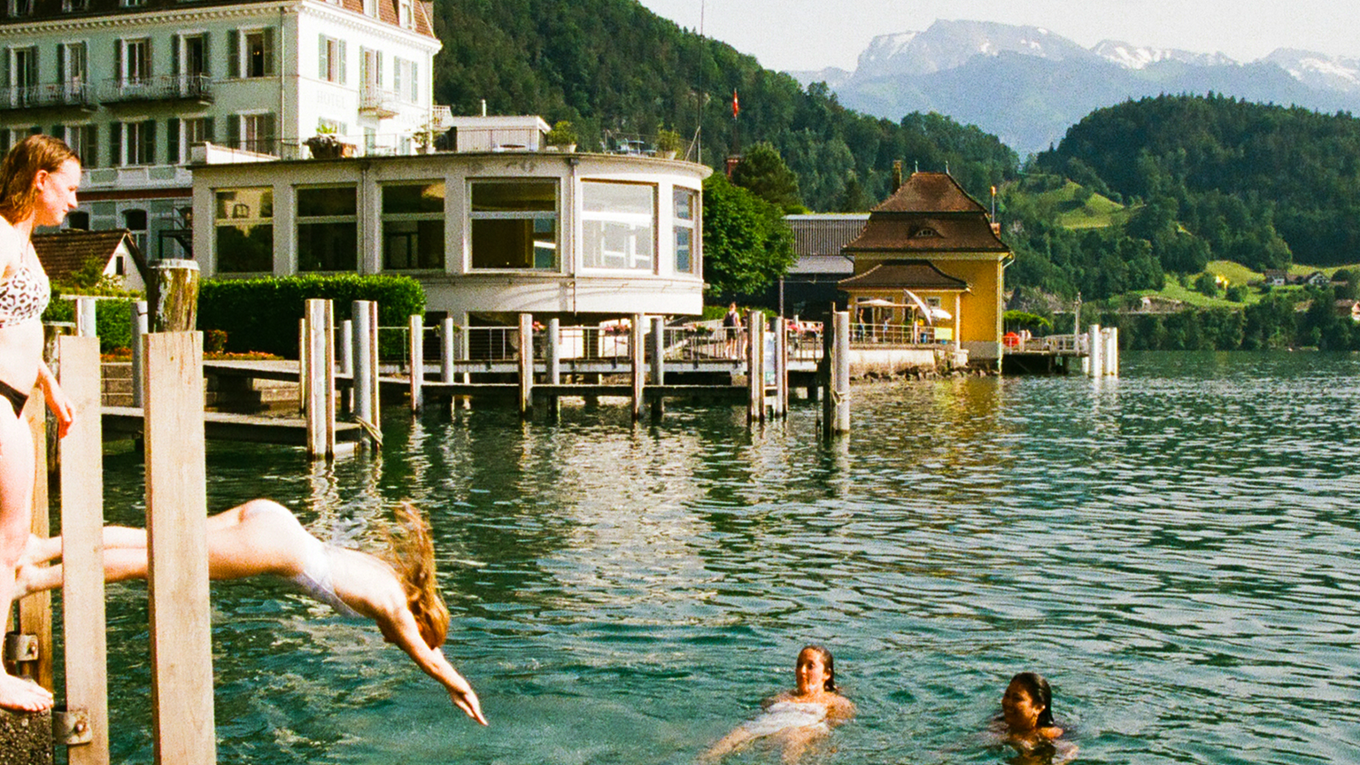 Two women jumping into a lake in Switzerland.
