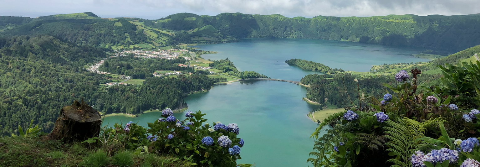 Aerial view of Sete Cidades lakes surrounded by lush green mountains and hydrangeas on São Miguel Island in the Azores