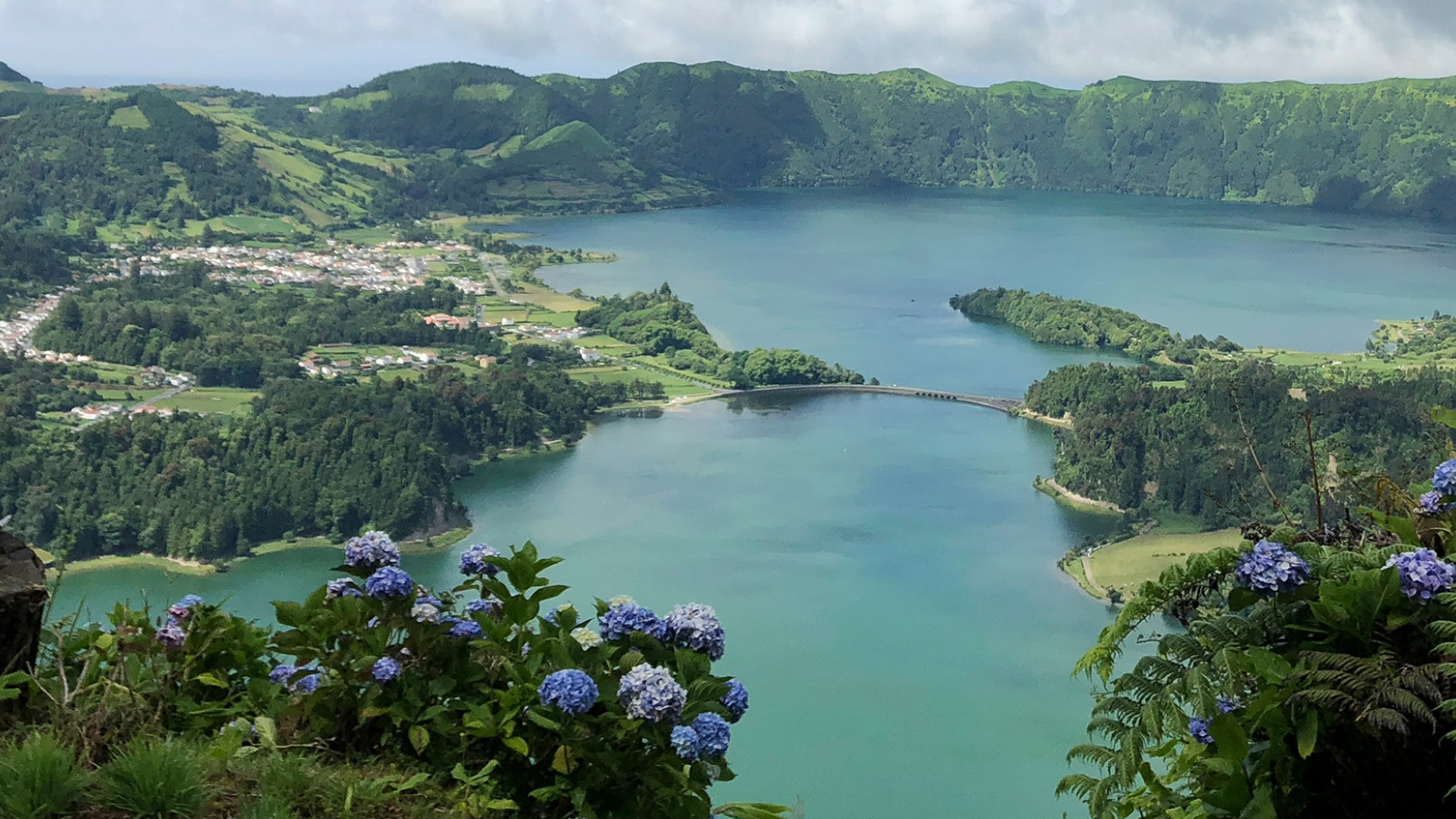 Aerial view of Sete Cidades lakes surrounded by lush green mountains and hydrangeas on São Miguel Island in the Azores