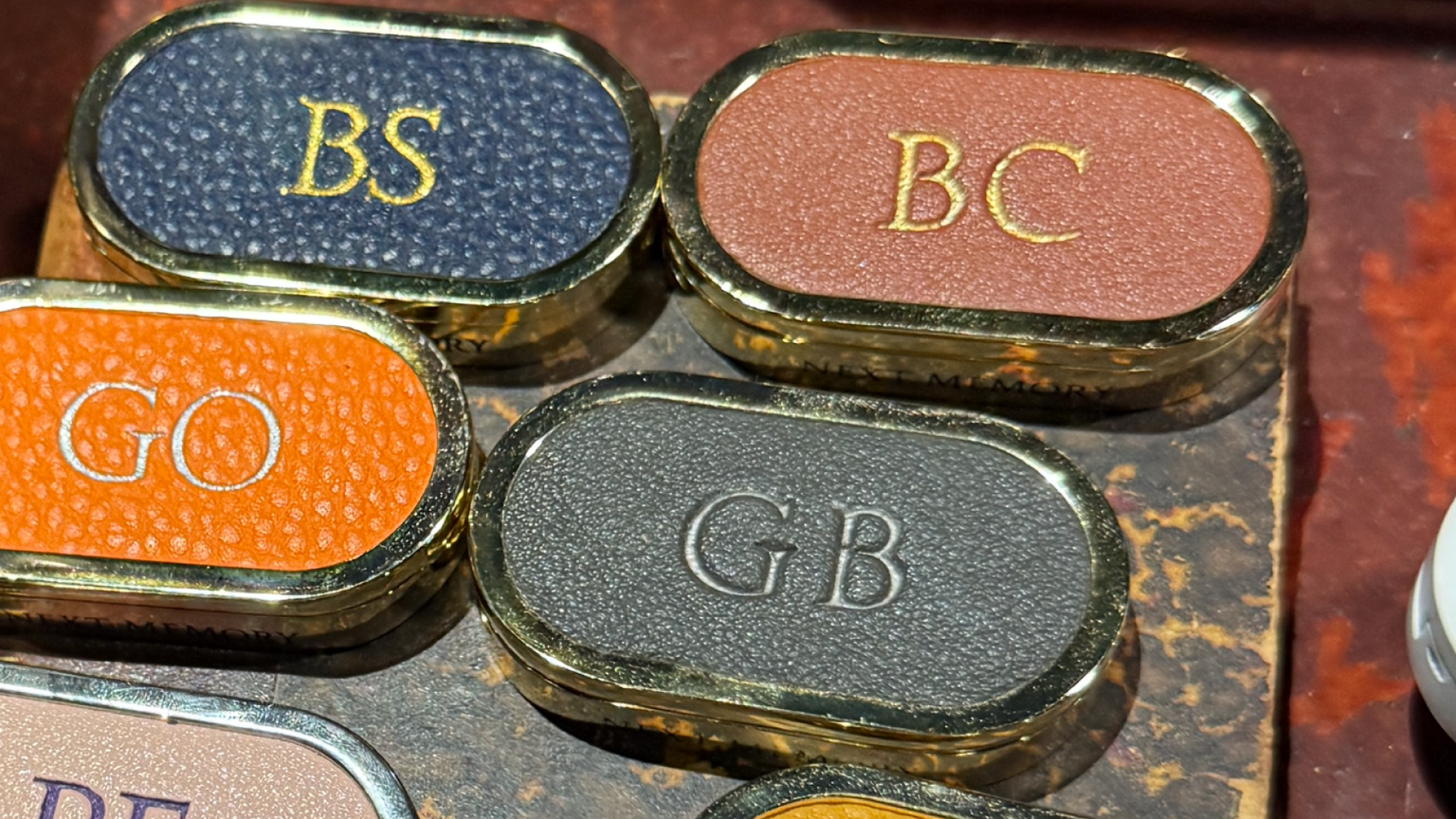 Multicolored leather and gold solid perfume cases with monogrammed initials