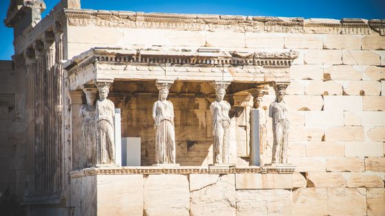The image shows the Caryatids, stone statues of female figures as columns, on the south porch of the Erechtheion in Athens, Greece.