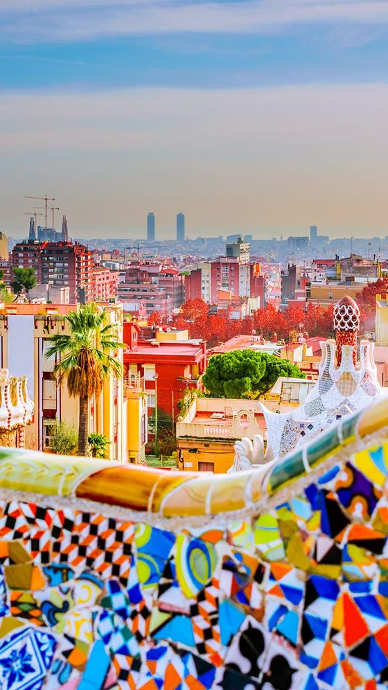 Colorful mosaic foreground with vibrant cityscape and skyline in the background, featuring unique architectural elements and distant buildings.
