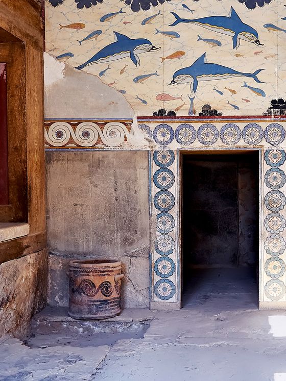 Ancient room with dolphin frescoes, ornate floral designs, and a large pottery jar near a shadowy doorway.
