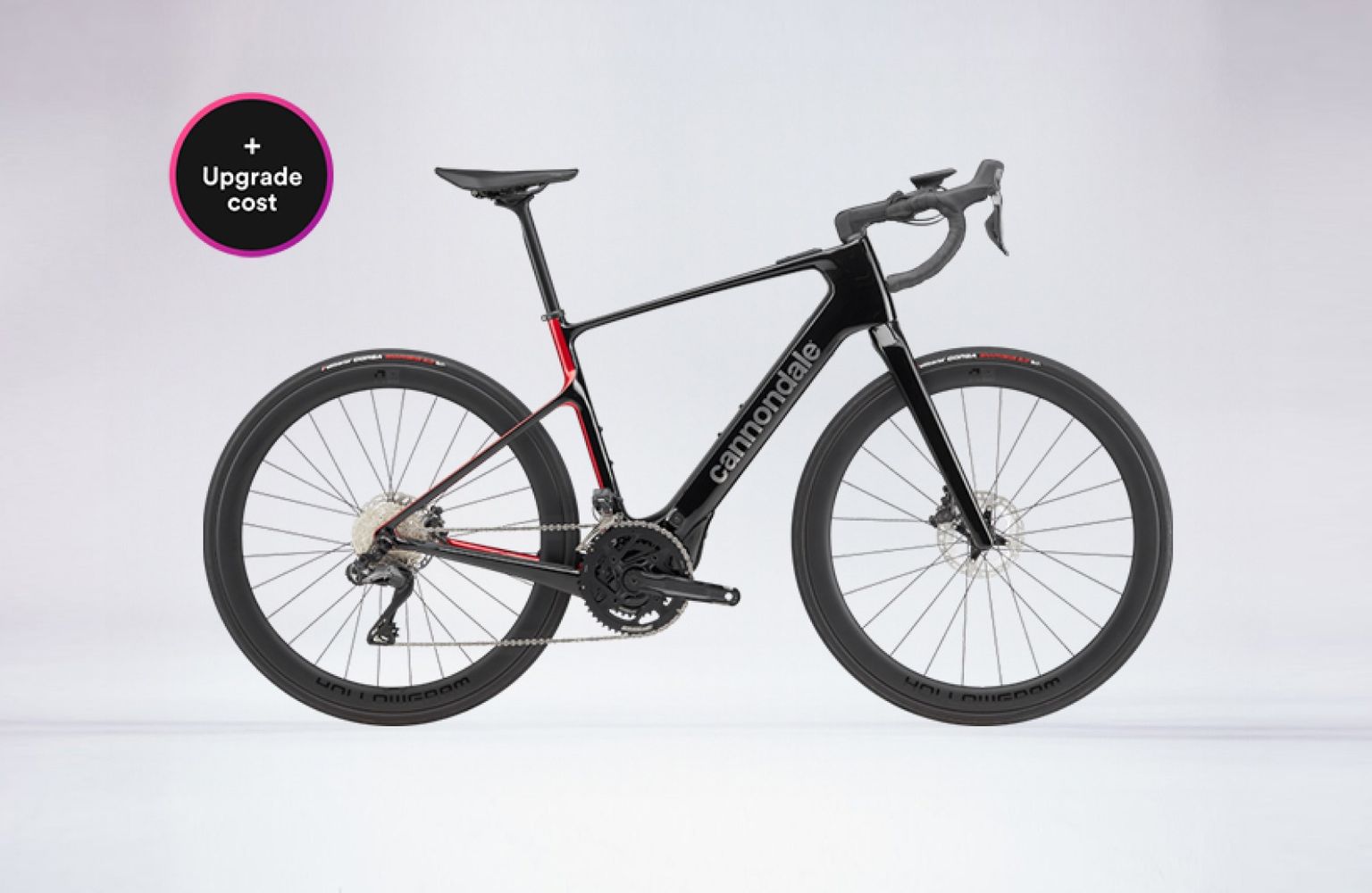 Black Cannondale road bike with disc brakes and aerodynamic frame, displayed on a light gray background. Circular "Upgrade cost" label in corner.