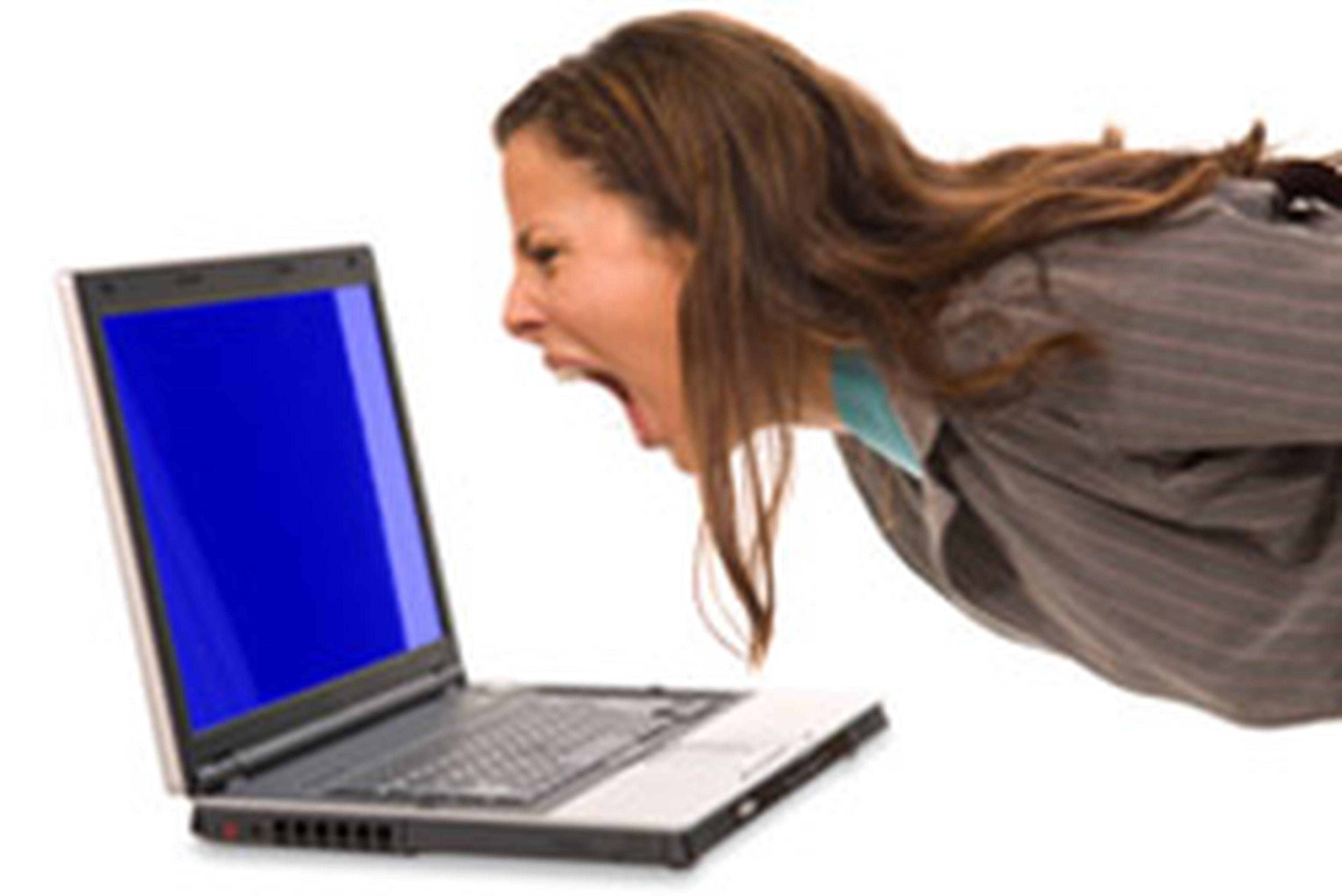 A brown haired woman screaming at her laptop screen